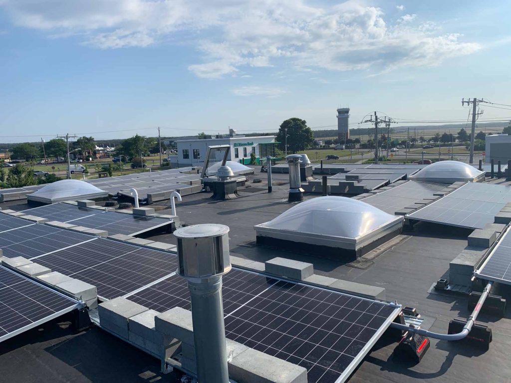 Solar panel installation on the roof of an Audi dealership in Cape Cod, MA, showcasing a clean energy solution for commercial power needs.