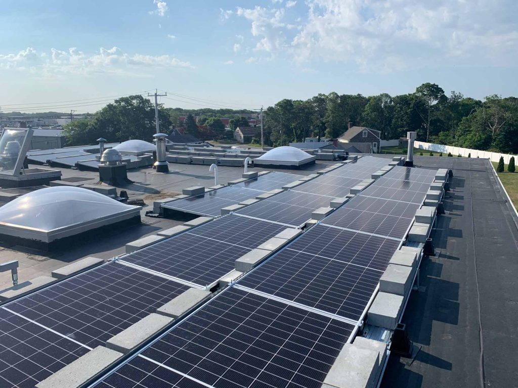 Audi dealership roof in Cape Cod, MA, featuring solar panel installation, showcasing clean energy technology for commercial power solutions.