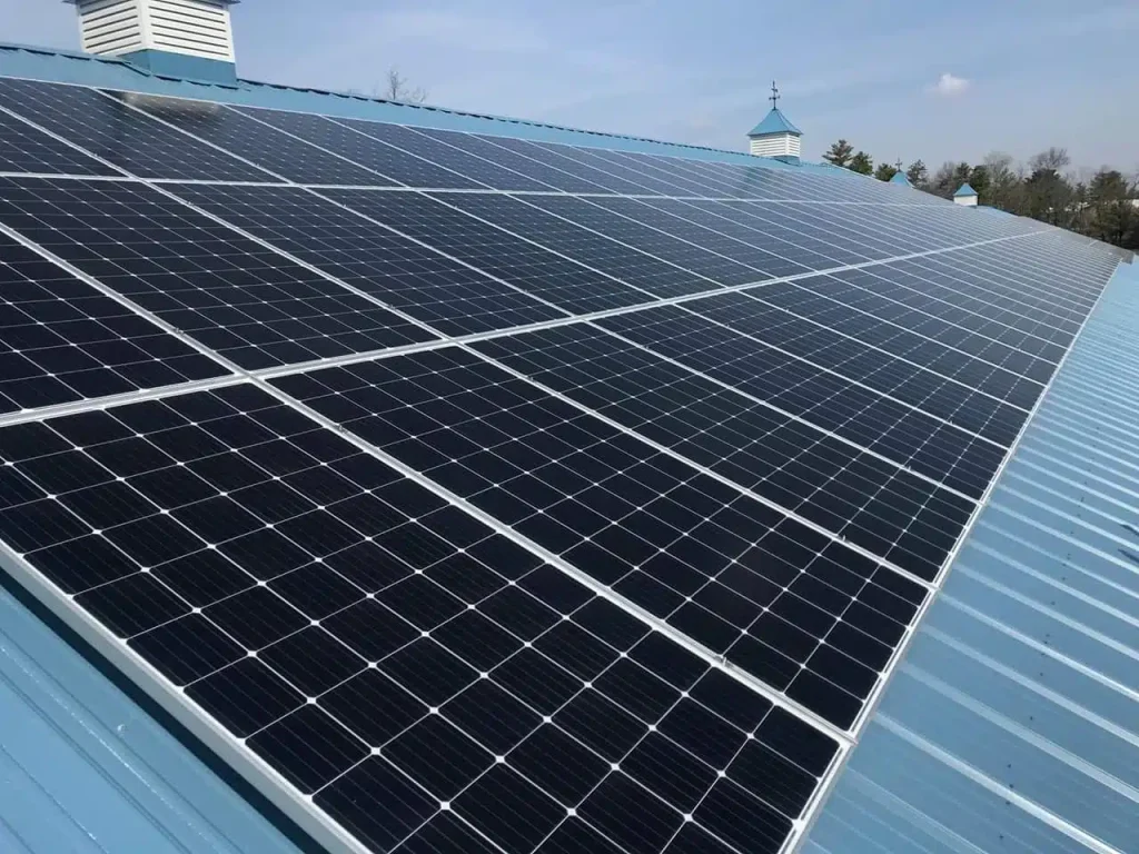 Solar panels installed on a blue metal roof, showcasing a clean energy solution for commercial buildings, emphasizing BD Electrical Services' expertise in solar power installations.