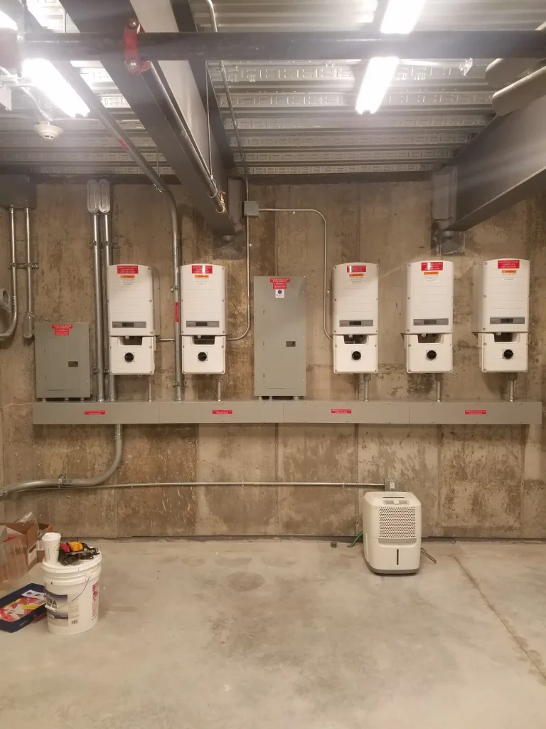 Commercial solar inverters mounted on a wall in a utility room, showcasing advanced solar energy technology for commercial power solutions.