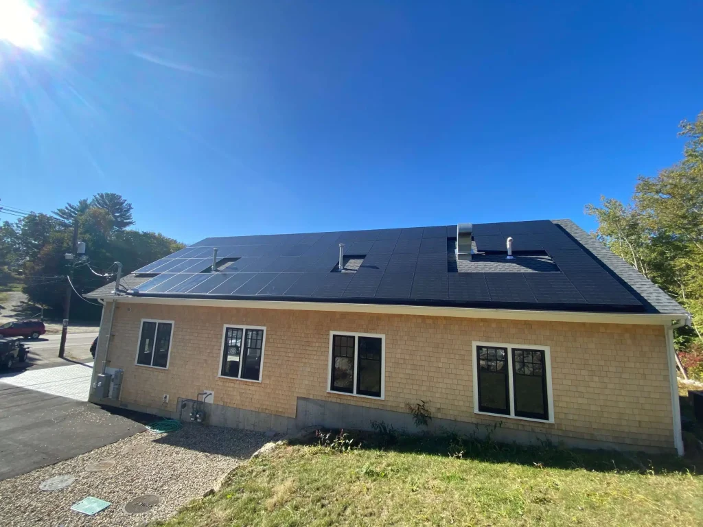 Small business building with solar panels installed on the roof, showcasing renewable energy solutions in a sunny environment.