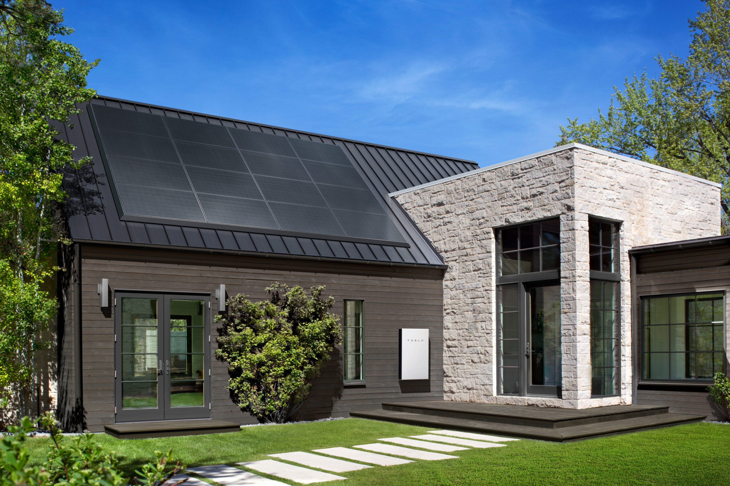 Home solar panels charging a battery energy storage system with excess solar power